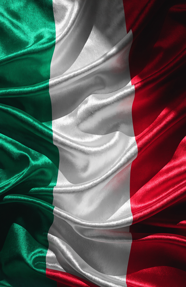 The Italian tricolour falls in green, white and red satin, each band lit along the crest of the fold