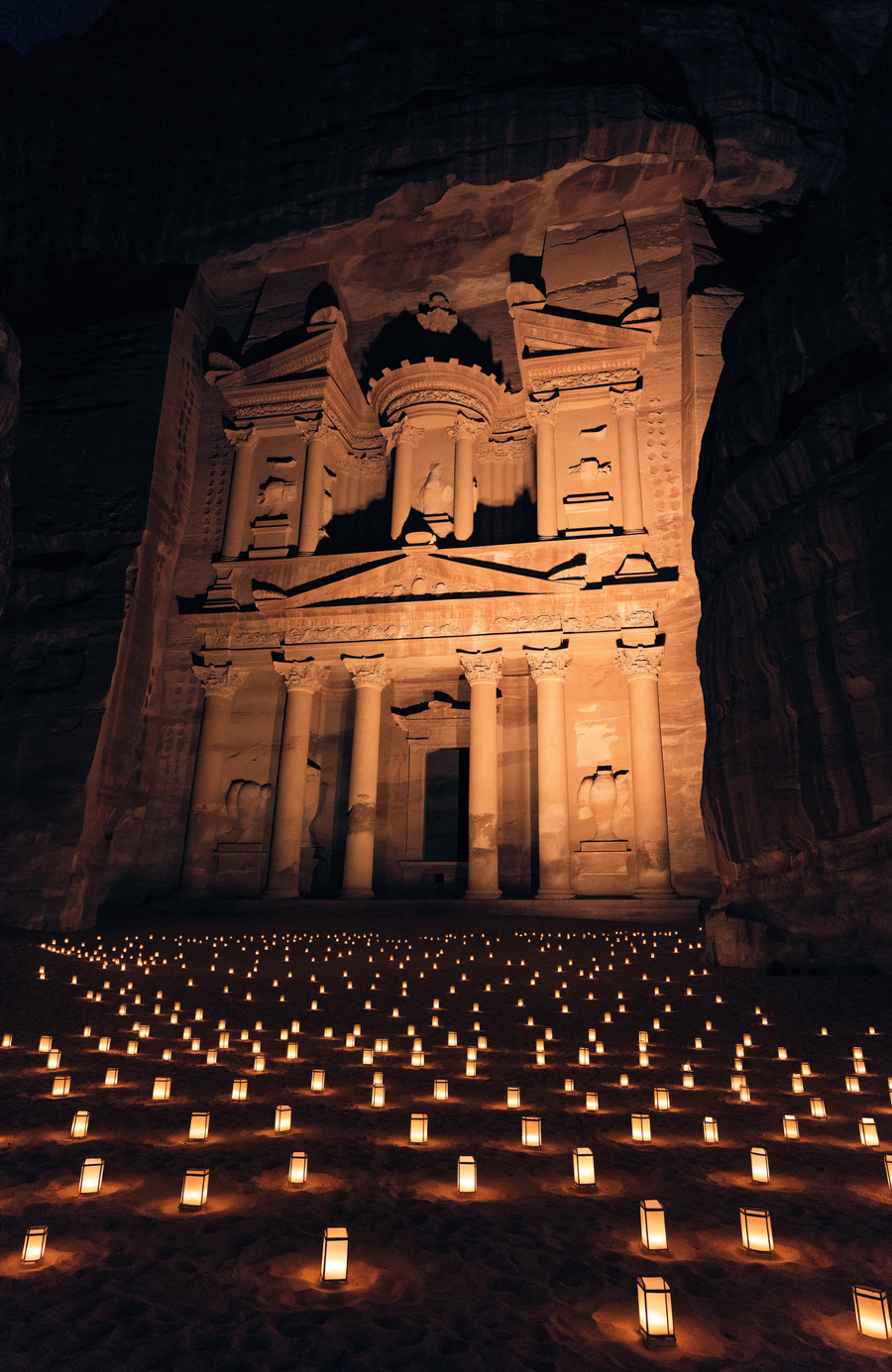 The Treasury at Petra is lit by hundreds of candles on the canyon floor, its rose stone warm against the dark